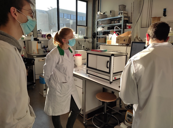 Photo of the granudrum at KU Leuven lab with scientifics gathering around the instrument